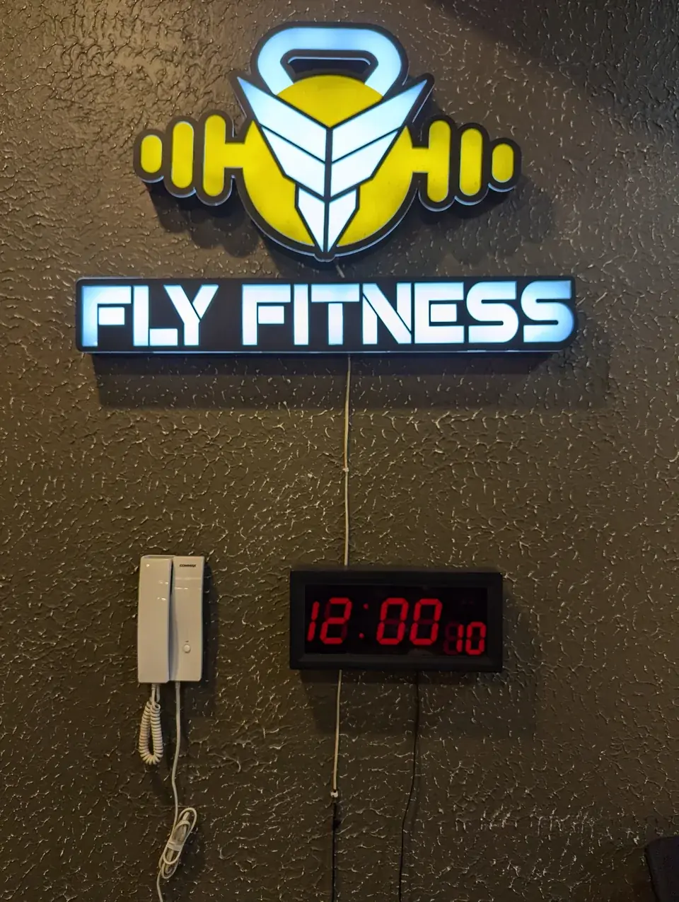 Fly Fitness logo sign on an interior wall