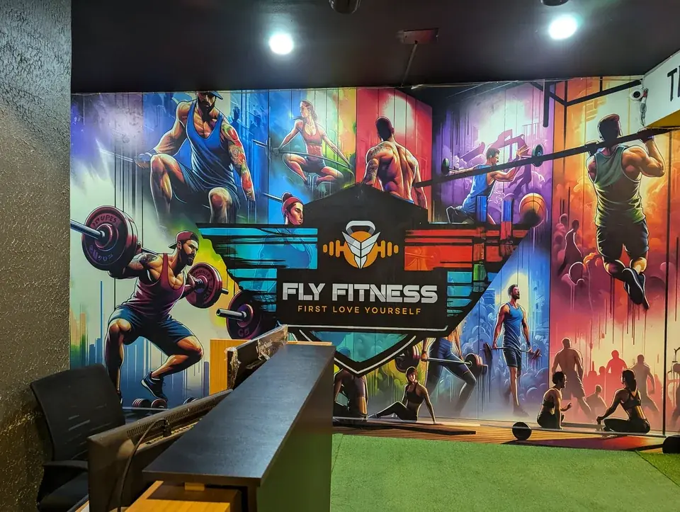 Fly Fitness reception desk with a colourful wall mural