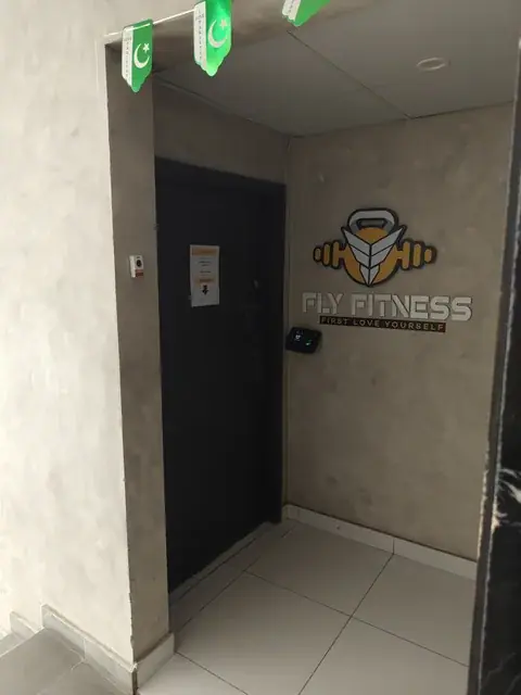 Studio entrance with a Fly Fitness wall logo beside the door